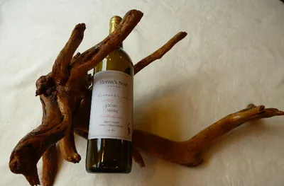 Branching driftwood wine cradle holding a bottle upright