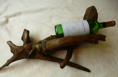 Long driftwood wine cradle with a bottle resting along the branch
